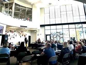 Participants in a large room listening to a presentation.