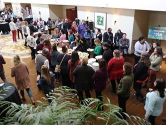 A large group of people gathering in a lobby for an event.